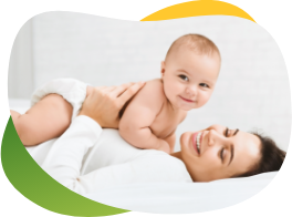 Sretna beba leži na svojoj nasmijanoj majci i radoznalo gleda u fotoaparat