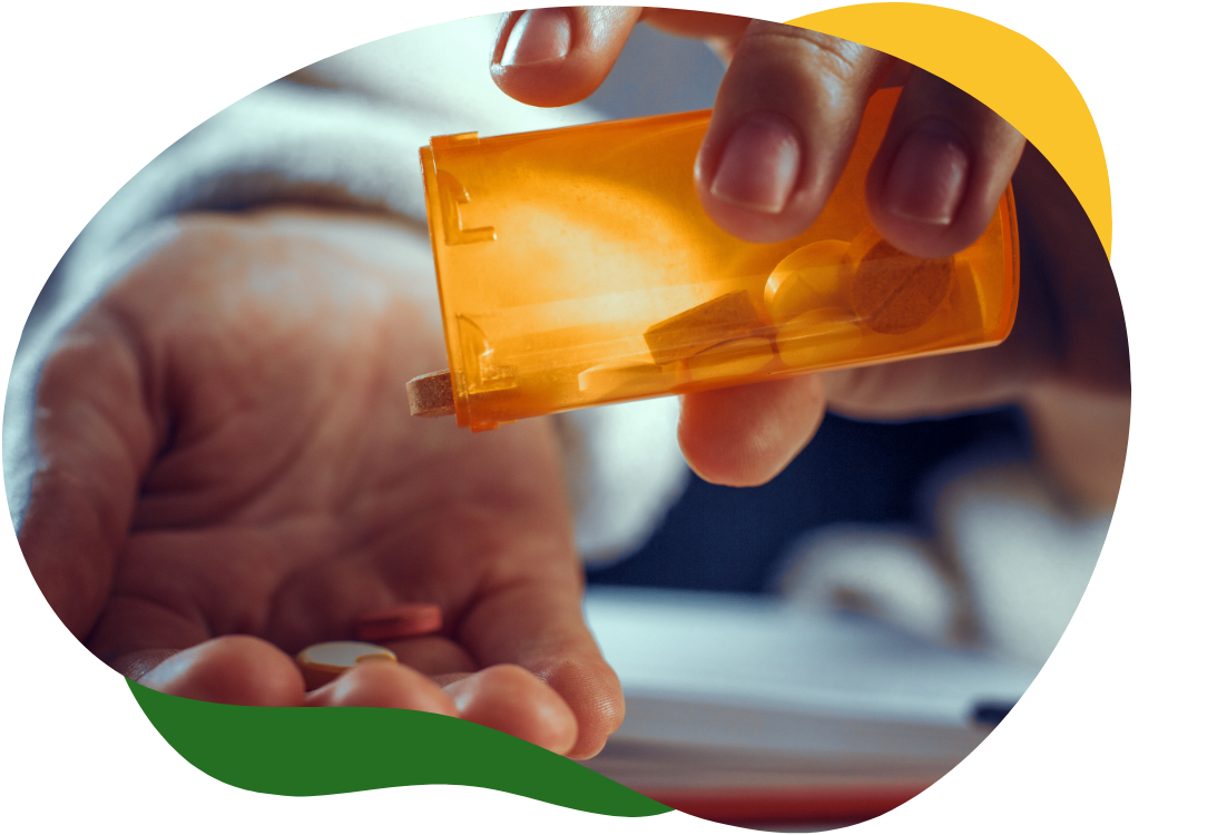 Ruka osobe koja sipa lijek iz bočice u svoj desni dlan