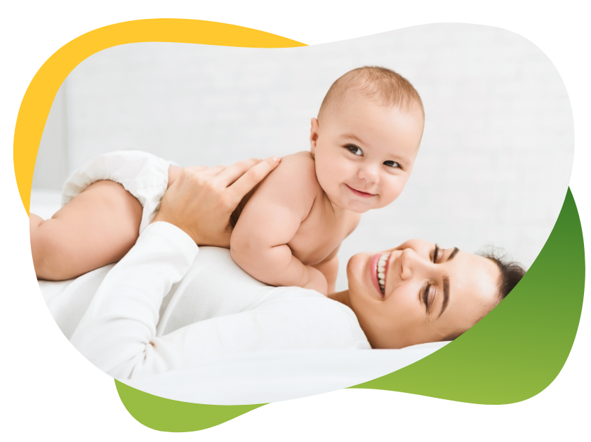 Sretna beba leži na svojoj nasmijanoj majci i radoznalo gleda u fotoaparat