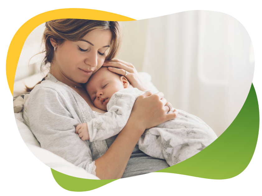 Mlada majka zatvorenih očiju drži usnulu bebu na grudima