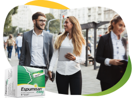 Dvije mlade žene i mladić u poslovnoj odjeći energično šetaju gradom, u prvom planu je pakiranje Espumisan Easy granula